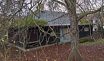 Lohelandhaus mit Baum im Vordergrund.