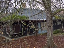 Lohelandhaus mit Baum im Vordergrund.